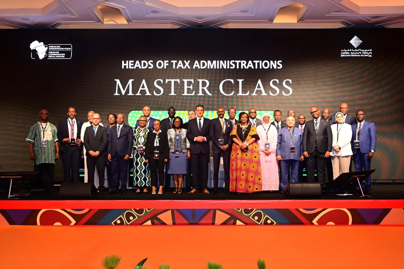 Delegates on stage in front of a Heads of Tax Administrations Master Class backdrop.