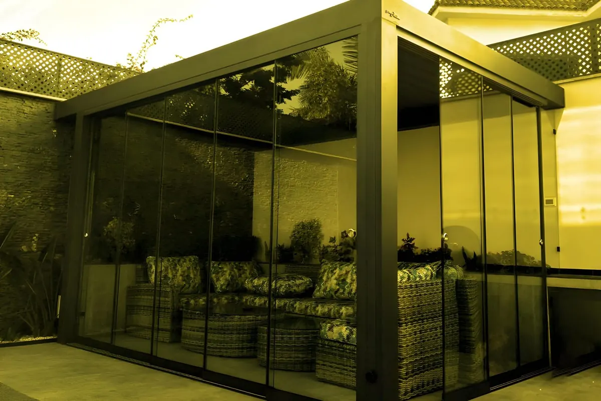 A glass enclosure with sofas inside.
