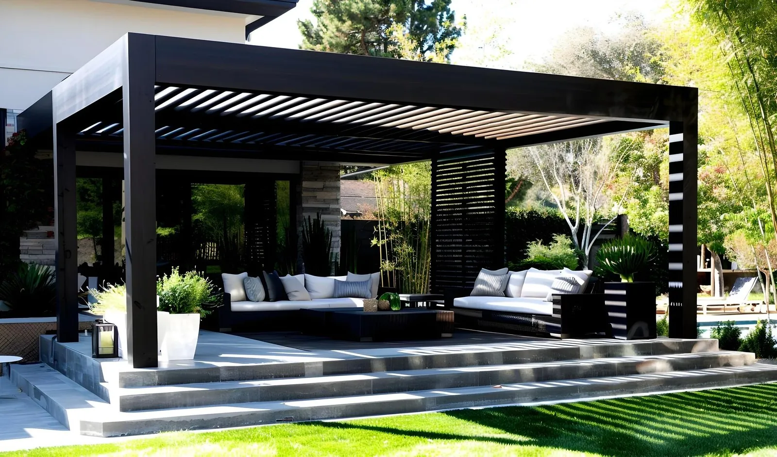 A black aluminium pergola over an outdoor lounge.