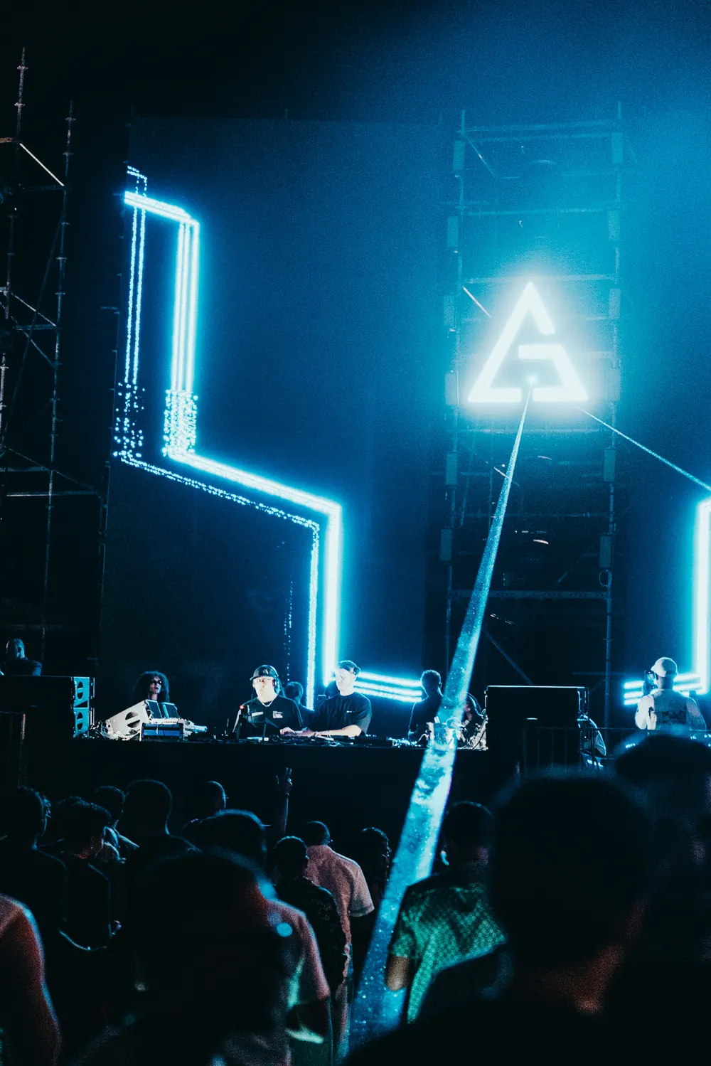A white beam cutting up from the stage past the LED pillars and the lit mark.