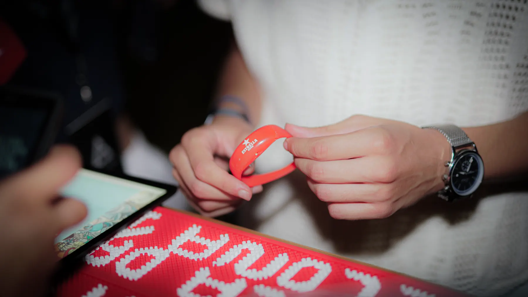 Close-up of a wristband being fastened at the entrance.